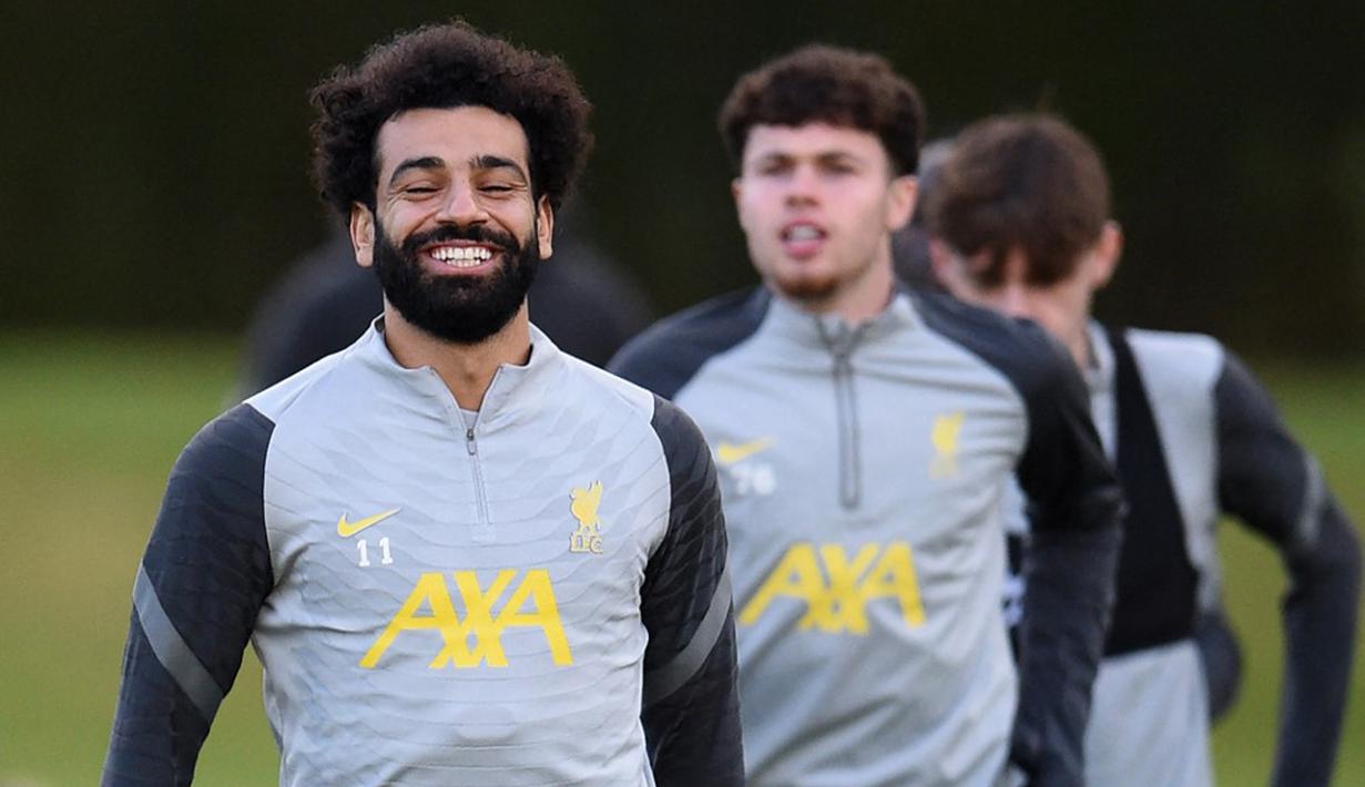 Pemain Liverpool Mohamed Salah (kiri) tertawa saat sesi latihan bersama rekan setimnya di tempat latihan mereka di Kirkby, Inggris, 6 Desember 2021. Liverpool akan menghadapi AC Milan pada pertandingan Grup B Liga Champions. (Oli SCARFF/AFP)