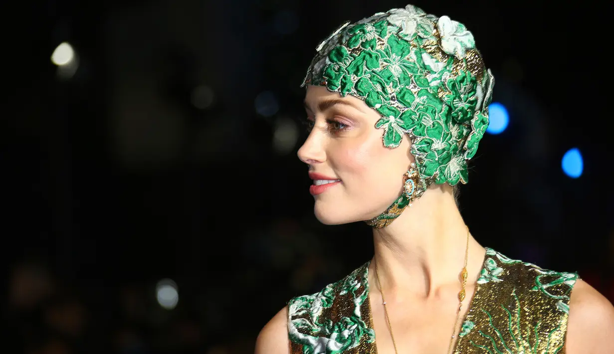 Aktris cantik Amber Heard berpose untuk fotografer setibanya menghadiri premier dunia film 'Aquaman' di London, Senin (26/11). Amber Heard memadukan penampilannya dengan topi renang bernuansa hijau dengan ornamen bunga. (Joel C Ryan/Invision/AP)