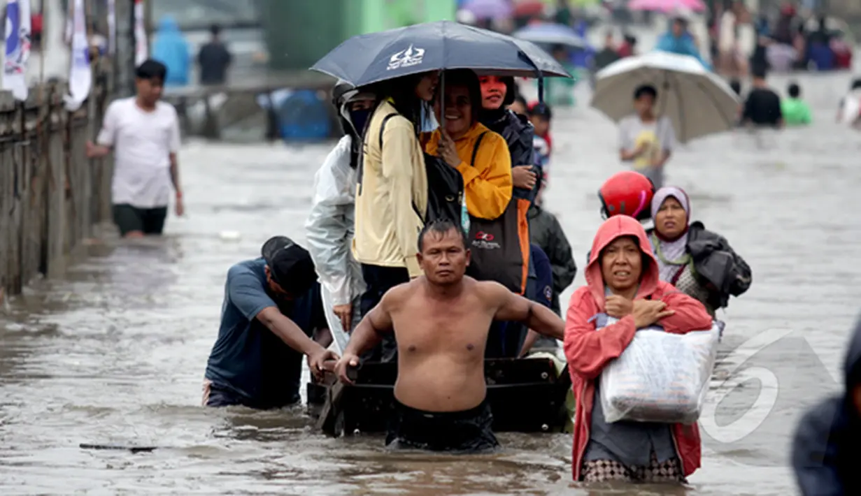 Tampak seorang bapak penarik jasa gerobak saat membawa penumpang untuk melawati banjir, Jakarta, Senin (6/2/2015). Jasa gerobak Mematok harga Rp. 30 ribu untuk membawa motor sedangkan untuk per orang hanya Rp. 10 ribu. (Liputan6.com/Faizal Fanani)