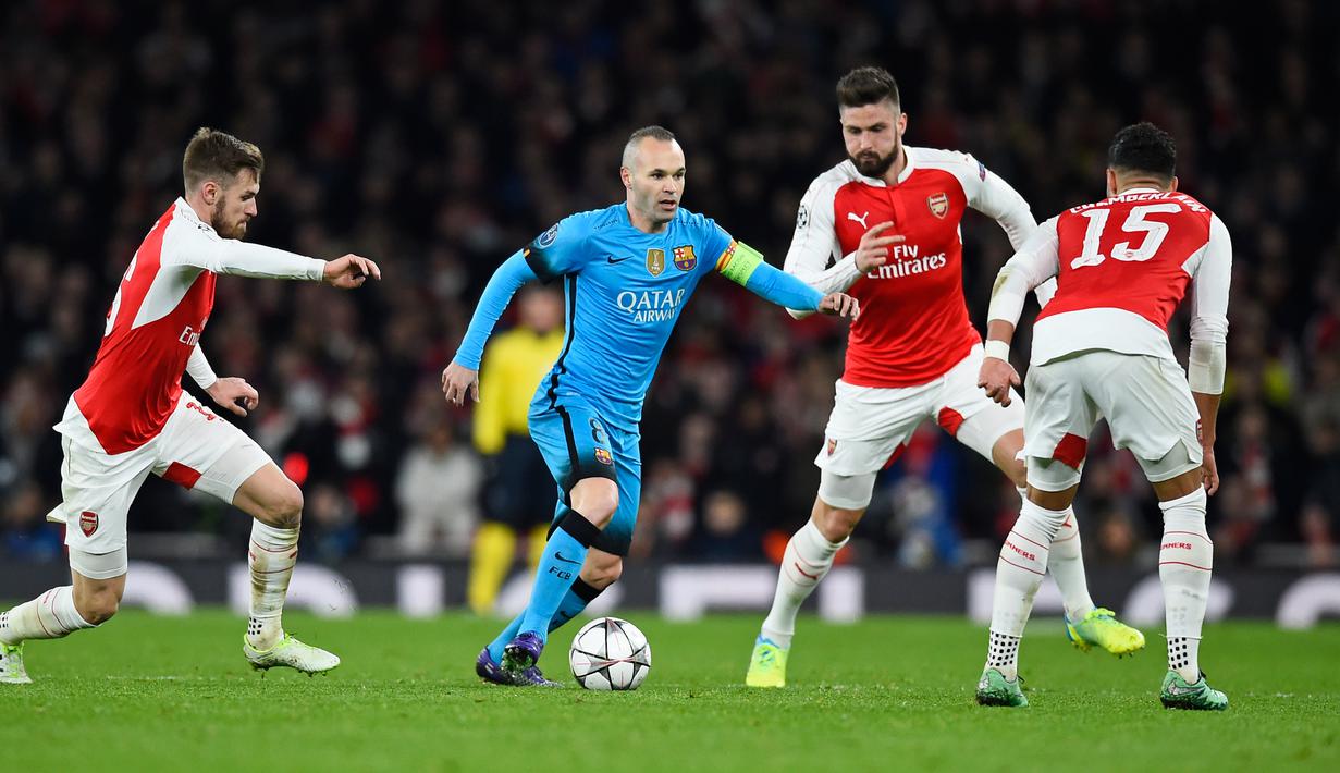 Gelandang Barcelona, Andres Iniesta berusaha membawa bola dari kawalan tiga pemain Arsenal pada leg pertama 16 besar Liga Champions di Stadion Emirates, Inggris (24/2). Barcelona menang atas Arsenal dengan skor 2-0. (Reuters/Dylan Martinez)