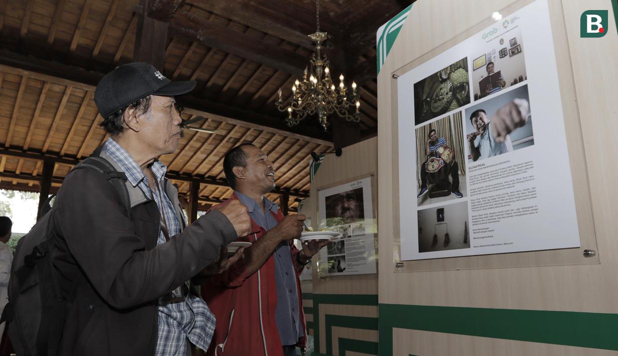 Pengunjung melihat pameran foto legenda di Yogyakarta, Rabu (18/7/2018). Pameran foto legenda olahraga Indonesia tersebut sekaligus peluncuran kampanye Grab "Kemenangan itu Dekat". (Bola.com/M Iqbal Ichsan)