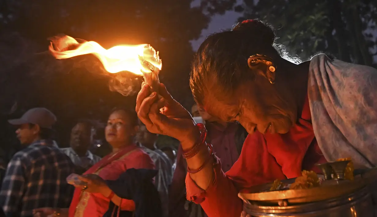 Seorang penyembah berdoa selama perayaan pada hari kesepuluh festival Dashain di sebuah kuil di Bhaktapur di pinggiran Kathmandu, Nepal (15/10/2021). (AFP/Prakash Mathema)