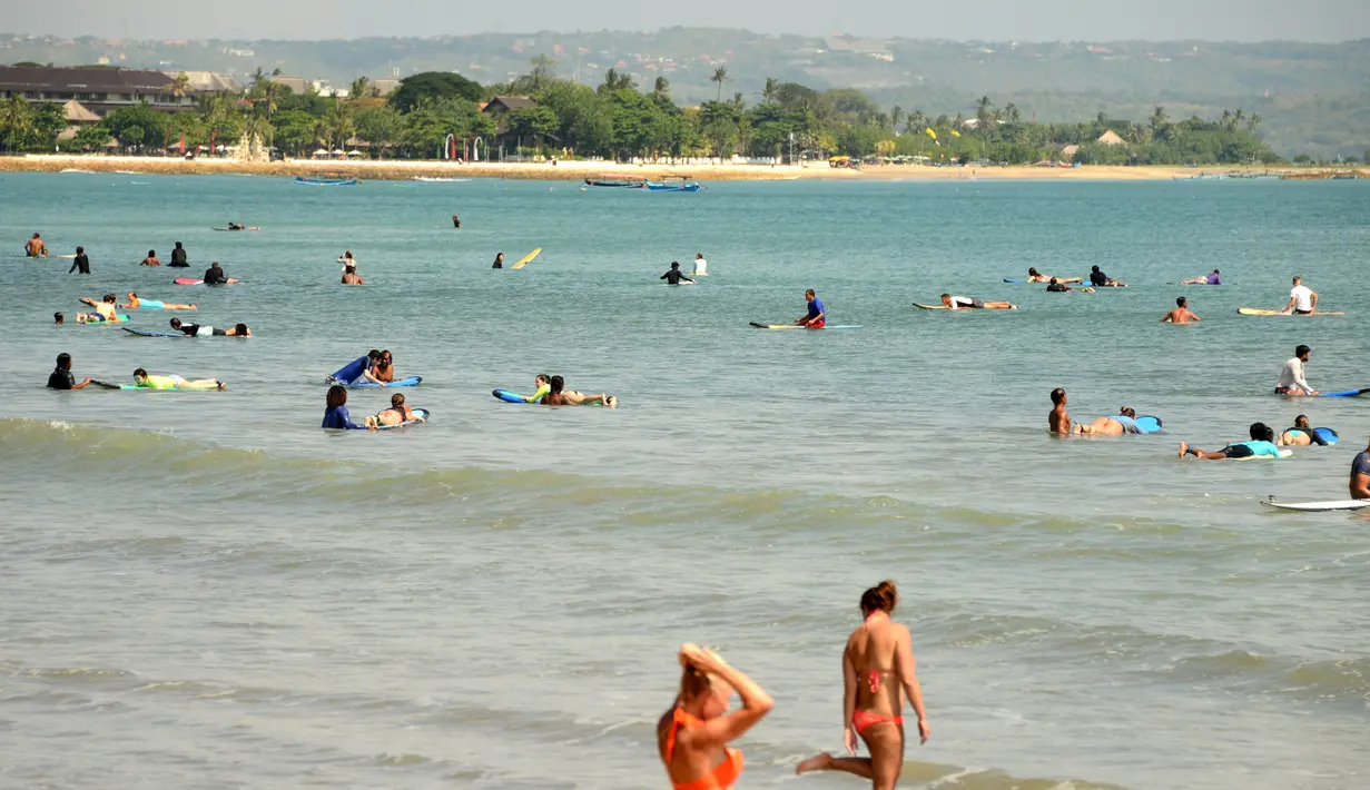 Turis berselancar di pantai Kuta dekat Denpasar di pulau resor Indonesia di Bali (3/5). Daerah ini merupakan sebuah tujuan wisata turis mancanegara dan telah menjadi objek wisata andalan Pulau Bali sejak awal tahun 1970-an. (AFP Photo/Sonny Tumbelaka)