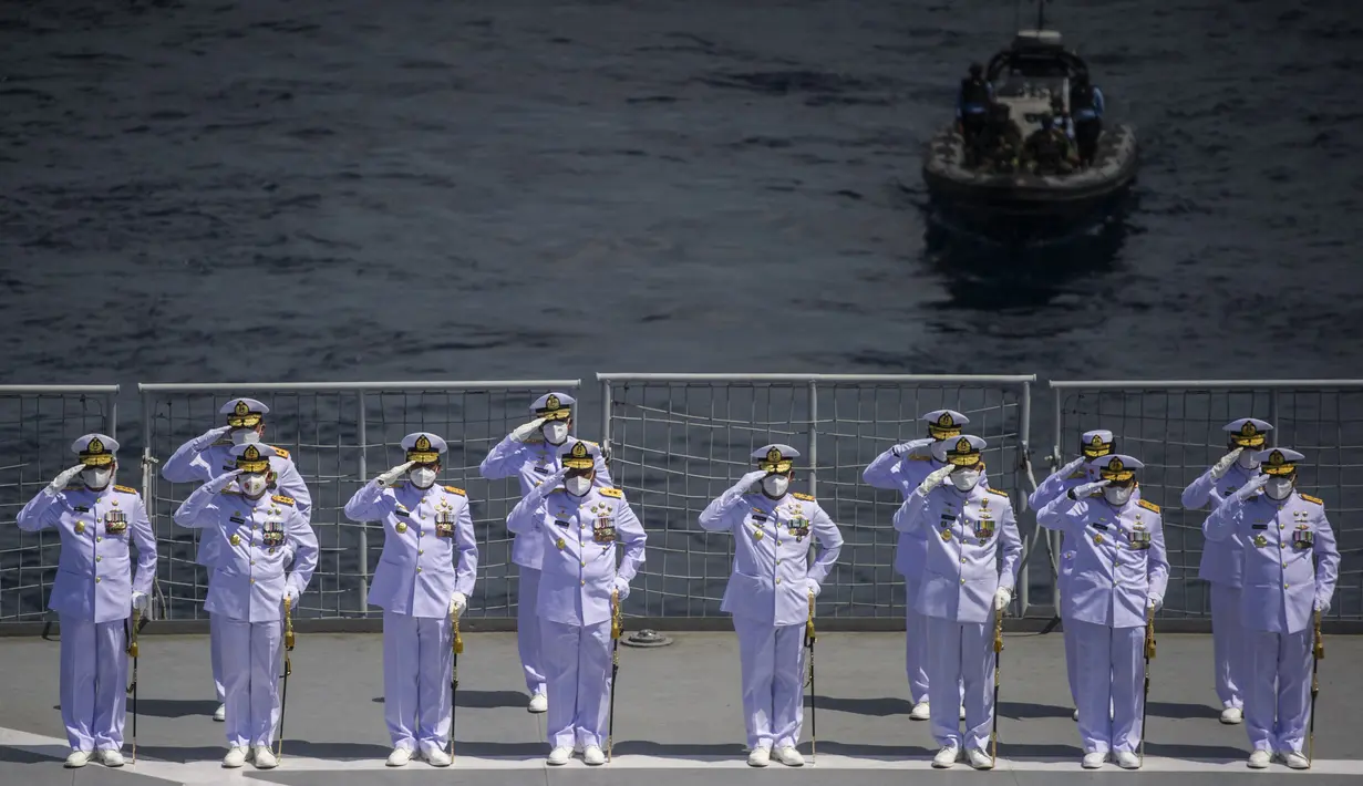 Perwira angkatan laut memberikan penghormatan saat upacara Tabur Bunga di geladak heli KRI Dr. Soeharso 990 di perairan utara Pulau Bali, Bali, Jumat (30/4/2021). Upacara itu digelar sebagai penghormatan terakhir bagi awak KRI Nanggala 402 yang gugur dalam medan tugas. (Juni Kriswanto/AFP)