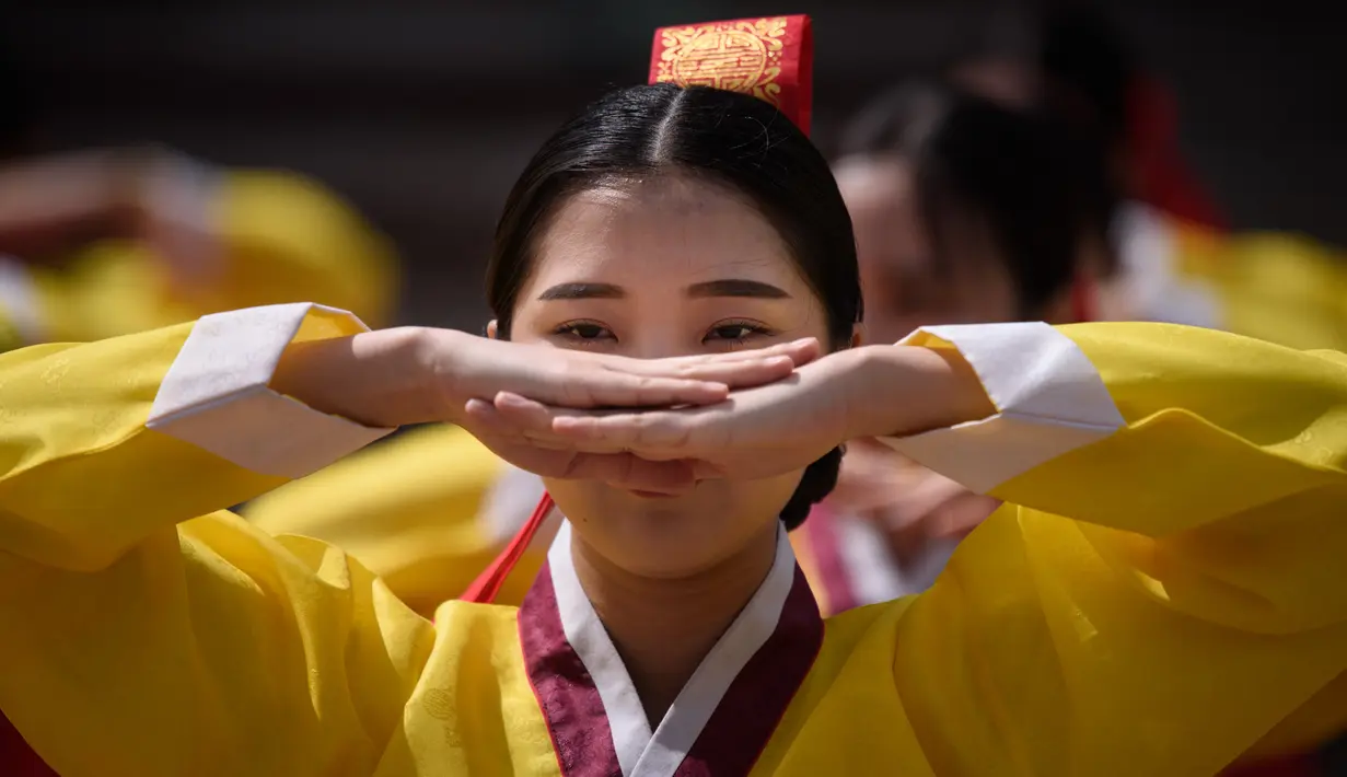 Seorang wanita muda melakukan ritual selama upacara “Coming of Age” di Namsan Hanok Village, Seoul, Senin (20/5/2019). Di Korea Selatan, Coming of Age Day atau hari kedewasaan dirayakan secara nasional setiap tahun pada hari Senin ketiga di bulan Mei. (Ed JONES/AFP)