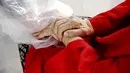 Gregg MacDonald menggenggam tangan ibunya Chloe MacDonald (84) di tenda pelukan di luar pusat bantuan kehidupan Desa Juniper, Louisville, Cololardo, Amerika Serikat, 3 Februari 2021. Di Brasil dan Inggris, orang-orang menyebut tenda pelukan sebagai tirai pelukan. (AP Photo/Thomas Peipert)