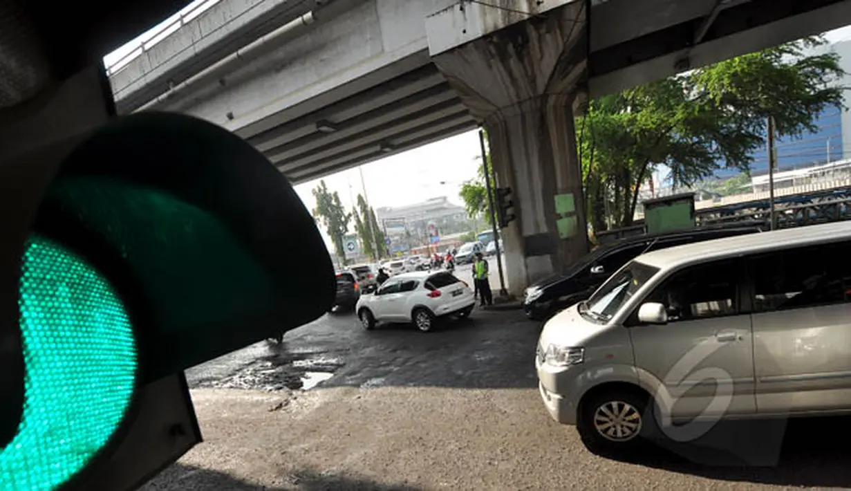Sejumlah kendaraan memperlambat laju kendaraannya ketika melintasi jalan rusak dan berlubang di Jalan RE Martadinata, Jakarta, Senin (16/2/2015). (Liputan6.com/Faizal Fanani)
