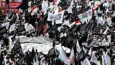 Massa peserta aksi 299 membawa bendera hitam berlafazkan kalimat tauhid di depan gedung MPR/DPR, Senayan, Jakarta, Jumat (29/9). Tuntutan aksi sendiri yakni menolak Perppu nomor 2 tahun 2017 tentang organisasi masyarakat (ormas). (Liputan6.com/JohanTallo)