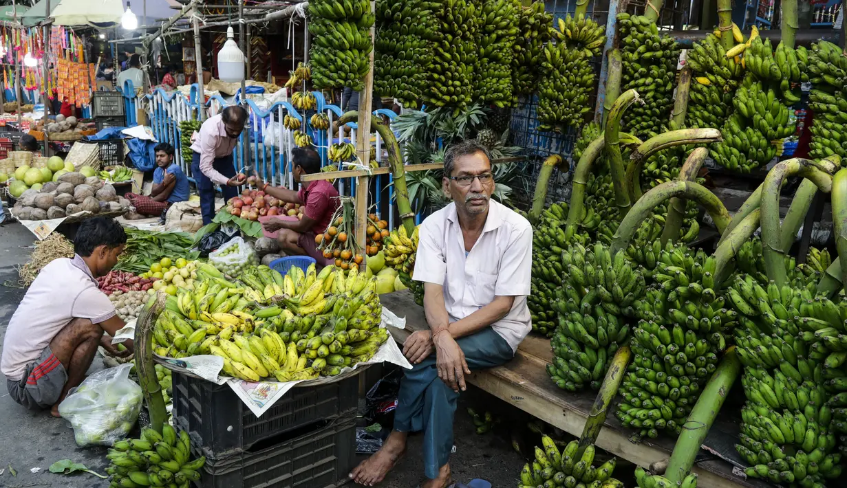 Seorang penjual pisang menunggu pembeli di kios pinggir jalan menjelang festival Hindu Chhath, di Kolkata, India (9/11/2021). Selama Chhath, festival Hindu kuno yang populer di kalangan kelas pekerja, ritual dilakukan untuk berterima kasih kepada Dewa Matahari. (AP Photo/Bikas Das)