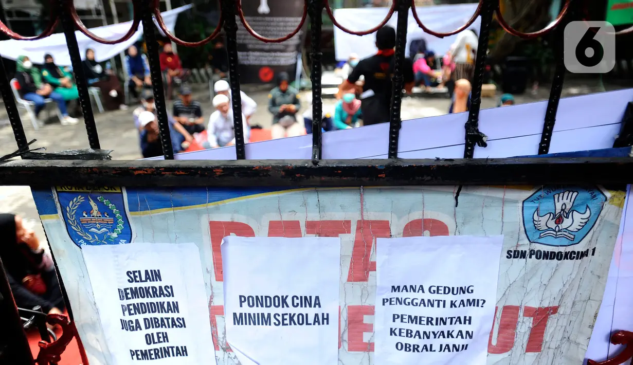 Orangtua murid bertahan dalam gedung saat pasukan Satpol PP hendak mengosongkan bangunan SDN Pondok Cina 1, Depok, Jawa Barat, Minggu (11/12/2022). Ketegangan dan adu argumentasi antara petugas dan sejumlah orang yang mengaku sebagai kuasa hukum orang tua siswa pun tak terhindarkan. (merdeka.com/Arie Basuki)
