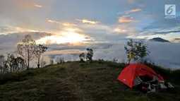 Tenda pendaki terlihat berada di Pos 2 Gunung Sumbing dengan latar belakang pemandangan Gunung Sindoro saat senja di Wonosobo, Jawa Tengah (3/4). Gunung ini memiliki pemandangan yang indah serta jalur terjal dan ekstrem dari basecamp hingga puncak Rajawali. (merdeka.com/Iqbal S. Nugroho)
