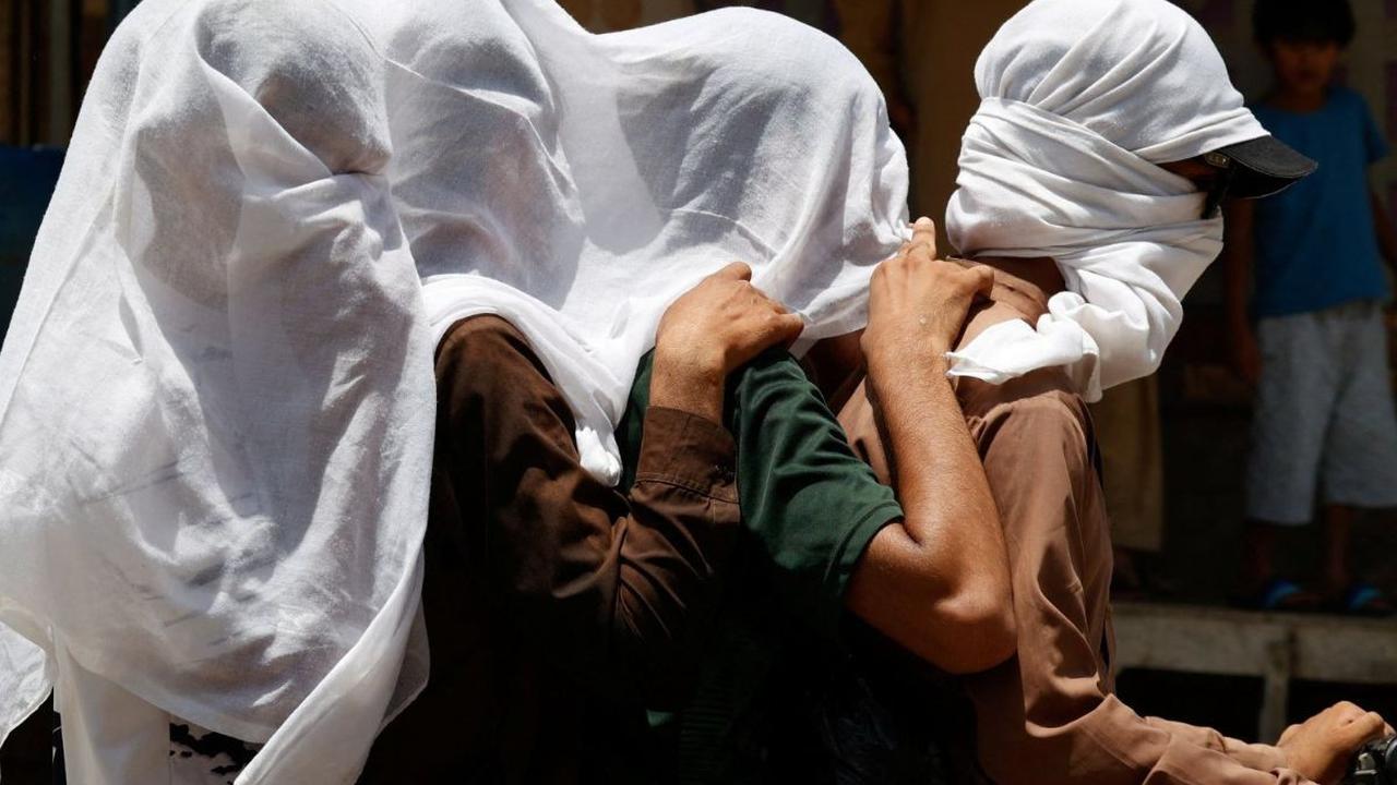 Sejumlah pria mengendarai sepeda motor sambil menutupi kepalanya dengan kain basah untuk menghindari terik matahari yang menyengat di Jacobabad, Provinsi Sindh, Pakistan, pada 26 Mei 2024. Suhu di Provinsi Sindh, Pakistan dilaporkan melonjak hingga 52 der