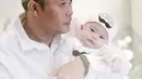 Momen saat Adzam belum lama lahir dalam gendongan sang ayah, Sule. Keduanya kompak memakai baju berwarna putih. (Foto: Instagram/@adzam_adriansyah)