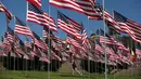Seorang anak perempuan berjalan diantara 3.000 bendera AS pada peringatan 15 tahun bagi para korban 11 September 2001 di Malibu, California, (11/09). Ribuan bendera AS juga terbang tinggi di New York.  (REUTERS/Lucy Nicholson)