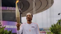 Aksi bintang rap kenamaan Amerika Serikat, Snoop Dog, membawa obor api Olimpiade 2024 atau torch relay di Paris, Jumat (26/7/2024). (Dok. Snoop Dog)