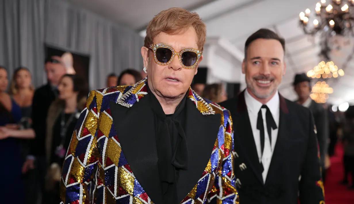Elton John hadir bersama dengan suaminya, David Furnish. (CHRISTOPHER POLK / GETTY IMAGES NORTH AMERICA / AFP)
