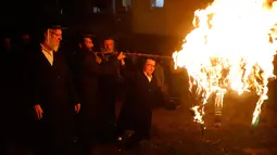 Sekelompok Yahudi ultra ortodoks antizionis menyalakan api unggun di Yerusalem ultra-Ortodoks Mea Shearim, Rabu (2/5). Dalam perayaan Lag BaOmer, ribuan orang Yahudi akan menyalakan api unggun besar. (MENAHEM KAHANA / AFP)