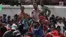 Seorang pengemis menggendong anaknya menunggu sedekah Imlek di depan Wihara Dharma Bhakti, Petak Sembilan, Jakarta, Jumat (16/2). Mereka selalu hadir setiap Imlek untuk menerima angpao dari jemaah yang datang bersembahyang. (Liputan6.com/Arya Manggala)