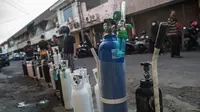 Antrean warga untuk mengisi ulang tabung oksigen di stasiun pengisian di kota Surabaya, Kamis (15/7/2021). Antrean yang terjadi di agen pengisian ulang oksigen itu disebabkan meningkatnya permintaan kebutuhan oleh warga. (Juni Kriswanto / AFP)