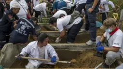 Relawan saat menggali makam tanpa identitas di pemakaman Poh Teck Tung, Thailand, Selasa (3/11/2015). Sebuah upacara kremasi massal Buddha akan diadakan pada bulan November untuk mendoakan para jenazah ini. (REUTERS/Athit Perawongmetha)