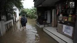 Warga beraktivitas saat banjir merendam kawasan Cipinang Melayu, Jakarta Timur, Senin (5/2). Genangan air terlihat memenuhi jalan di pemukiman warga. (Liputan6.com/Arya Manggala)