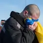 Seorang tentara Ukraina terlihat mencium bendera nasional negaranya setelah pertukaran tahanan dengan pihak Rusia. (X/@V_ZELENSKIY_OFFICIAL)
