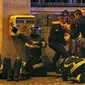 Petugas pemadam kebakaran menolong korban serangan di dekat Gedung Konser Bataclan. (Reuters)