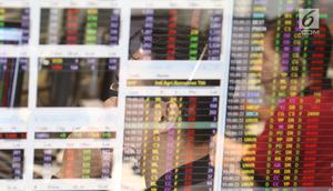 Pekerja mengamati pergerakan Indeks Harga Saham Gabungan (IHSG) di salah satu perusahaan Sekuritas, Jakarta, Rabu (14/11).  Indeks Harga Saham Gabungan (IHSG) berhasil bertahan di zona hijau pada penutupan perdagangan hari ini. (Liputan6.com/Angga Yuniar)