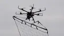 Drone yang dilengkapi dengan jaring saat diuji coba dalam latihan penanggulangan terorisme di Tokyo, Jepang, Minggu (17/1). Drone tersebut berguna untuk membantu pollisi menangkap para pelaku kejahatan teror.  (AFP/Toshifum Kitamura)