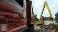 Alat berat dan truk mengangkut tumpukan sampah di pinggir kali Ciliwung Rawajati, Jakarta, Selasa (8/3/2016). Hujan yang mengguyur Bogor dua hari terakhir mengakibatkan banjir kiriman yang disertai sampah batang bambu. (Liputan6.com/Helmi Fithriansyah)