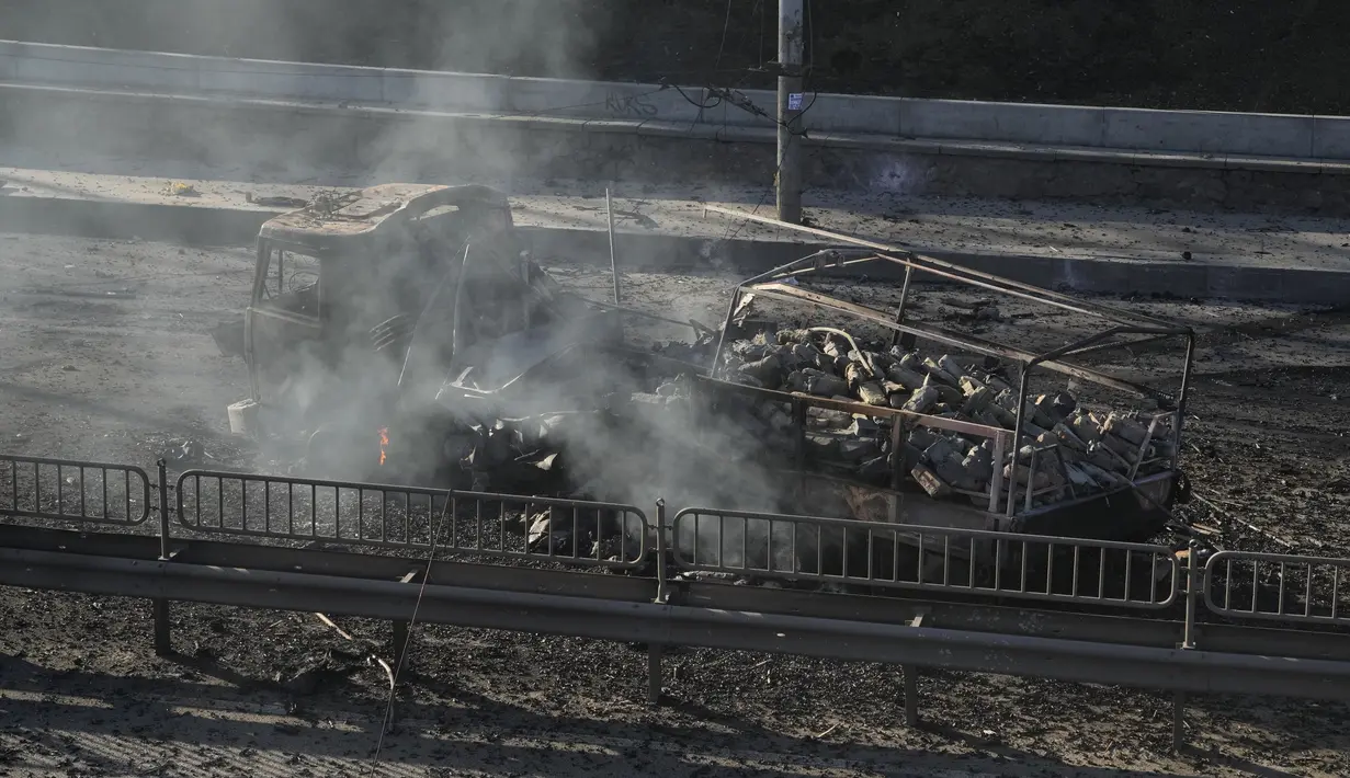 Puing-puing truk militer yang terbakar terlihat di jalan di Kiev, Ukraina, Sabtu (26/2/2022). Pasukan Rusia menyerbu ke arah ibu kota Ukraina pada Sabtu (26/2), dan pertempuran jalanan pecah saat pejabat kota mendesak penduduk untuk berlindung. (AP Photo/Efrem Lukatsky)