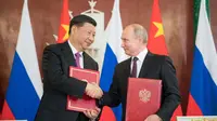 Presiden China Xi Jinping (kiri) berjabat tangan erat dengan Presiden Rusia Vladimir Putin (kanan) dalam sebuah pertemuan di Moskow (Xinhua)