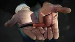 Marco Bacigalupi menunjukkan pipa rokok buatannya di Gavi, Italia (14/11). Pengrajin Bacigalupi memulai membuat pipa rokok dari kayu ini sejak tahun 80-an. (AFP Photo/Marco Bertorello)