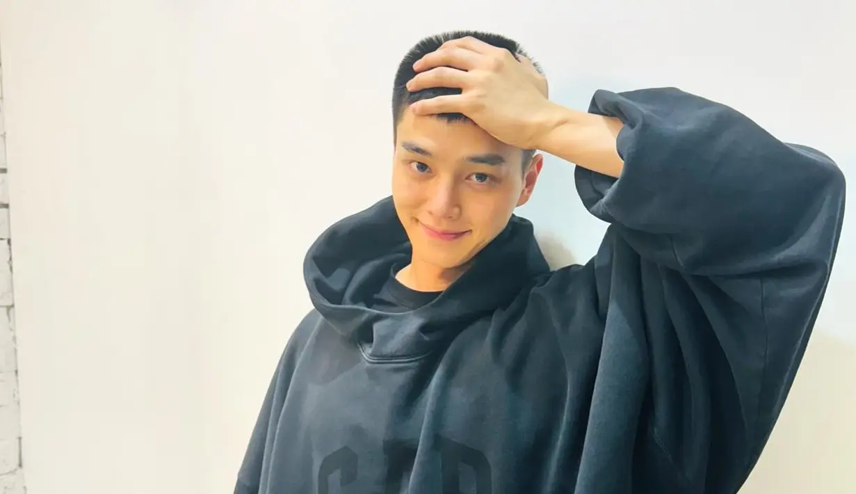 <p>Penggemar akhirnya dapat melihat potongan rambut cepak Song Kang untuk pertama kalinya. Dengan tersenyum malu dia memegang kepalanya. (Foto: Instagram/ songkang_b)</p>
