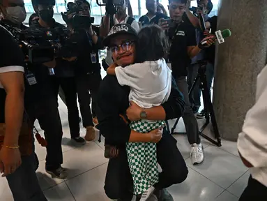 Seorang warga negara Thailand memeluk anggota keluarganya setelah tiba dengan penerbangan dari Israel di Bandara Internasional Suvarnabhumi di Bangkok, Kamis (12/10/2023). (Lillian SUWANRUMPHA / AFP)