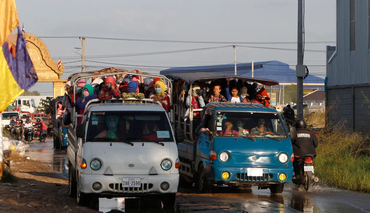 Para pekerja menaiki mobil bak terbuka sebagai transportasi harian mereka pulang ke rumah dari tempat kerja di sebuah pabrik di dekat desa Trapang Anchanh, di luar Phnom Penh, Kamboja (27/10). (AP Photo/Heng Sinith)