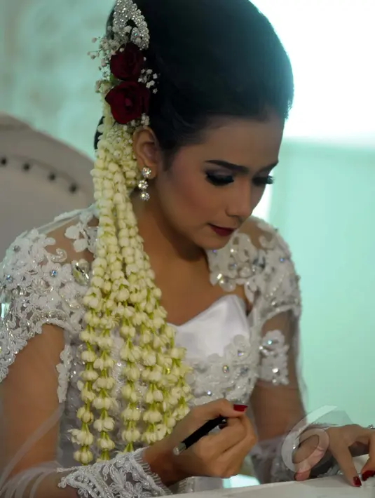 Sonya Fatmala tampak cantik mengenakan kebaya serba putih, lengkap dengan sanggul dan bunga mawar serta melati yang menghiasi rambutnya saat akad nikah di sebuah hotel kawasan TMII, Jakarta, Kamis (23/4/2015). (Liputan6.com/Panji Diksana)