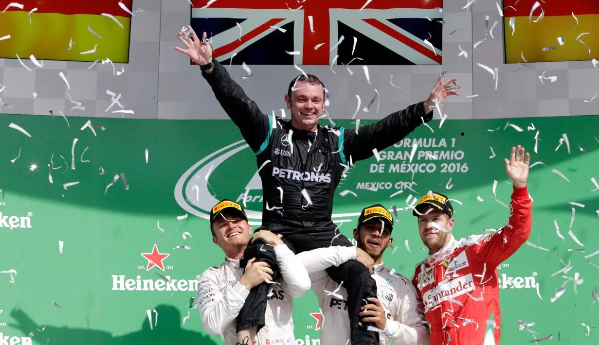 Lewis Hamilton dan Nico Rosberg mengangkat direktur teknis mereka, Paddy Lowe di atas podium setelah kedua pembalap Mercedes itu menempati posisi satu dan runner up di F1 Grand Prix Meksiko, Meksiko (30/10). (Reuters/Henry Romero)