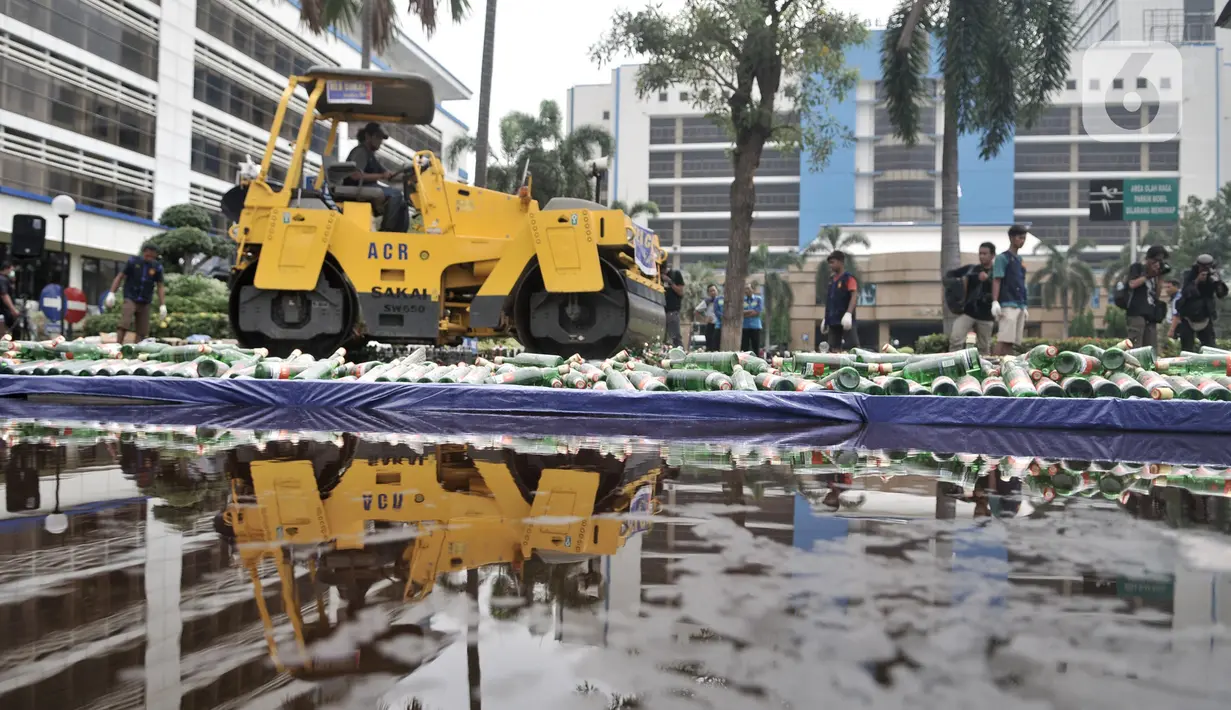 Petugas memusnahkan minuman keras dengan buldoser di Kantor Direktorat Bea Cukai, Jakarta, Kamis (19/12/2019). Dirjen Bea Cukai memusnahkan 2.777.114 batang rokok dan 14.719 botol minuman keras ilegal berbagai merek senilai Rp 6.462.090.500. (merdeka.com/Iqbal S Nugroho)
