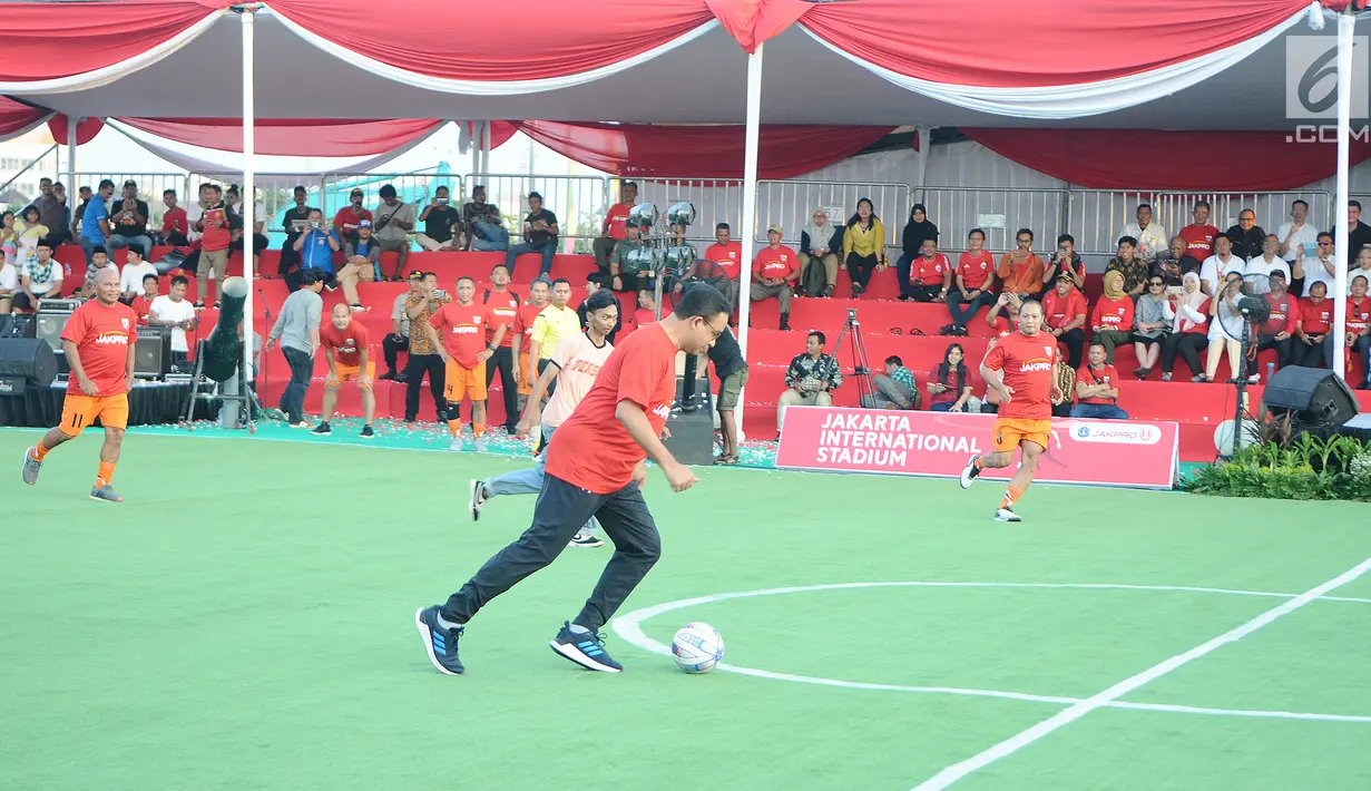 Gubernur DKI Jakarta Anies Baswedan bermain bola saat menghadiri Kick Off Pembangunan Jakarta International Stadium di Jakarta, Kamis (14/3). Stadion ini nantinya bakal digunakan sebagai markas Persija Jakarta. (Liputan6.com/Herman Zakharia)