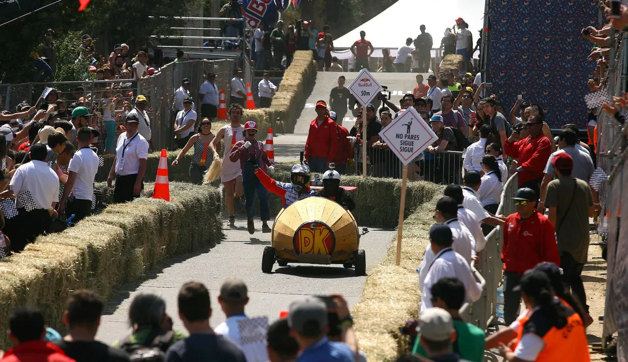 Penonton menyaksikan ajang balap mobil 'Kotak sabun' Red Bull Soapbox di Santiago, Chili, Minggu (27/11). Kejuaraan ini dinamakan balap kotak sabun, karena setiap kendaraan dibuat berbentuk kotak layaknya tempat sabun. (REUTERS/Jonathan Faus)