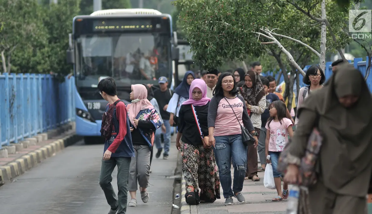 Penumpang menelusuri trotoar usai turun dari bus Transjakarta di Terminal Blok M, Jakarta, Minggu (1/7). Halte bus Transjakarta pertama di Ibu Kota ini kini terlihat kurang terawat dan minim sarana prasarana bagi penumpang. (Merdeka.com/Iqbal S. Nugroho)