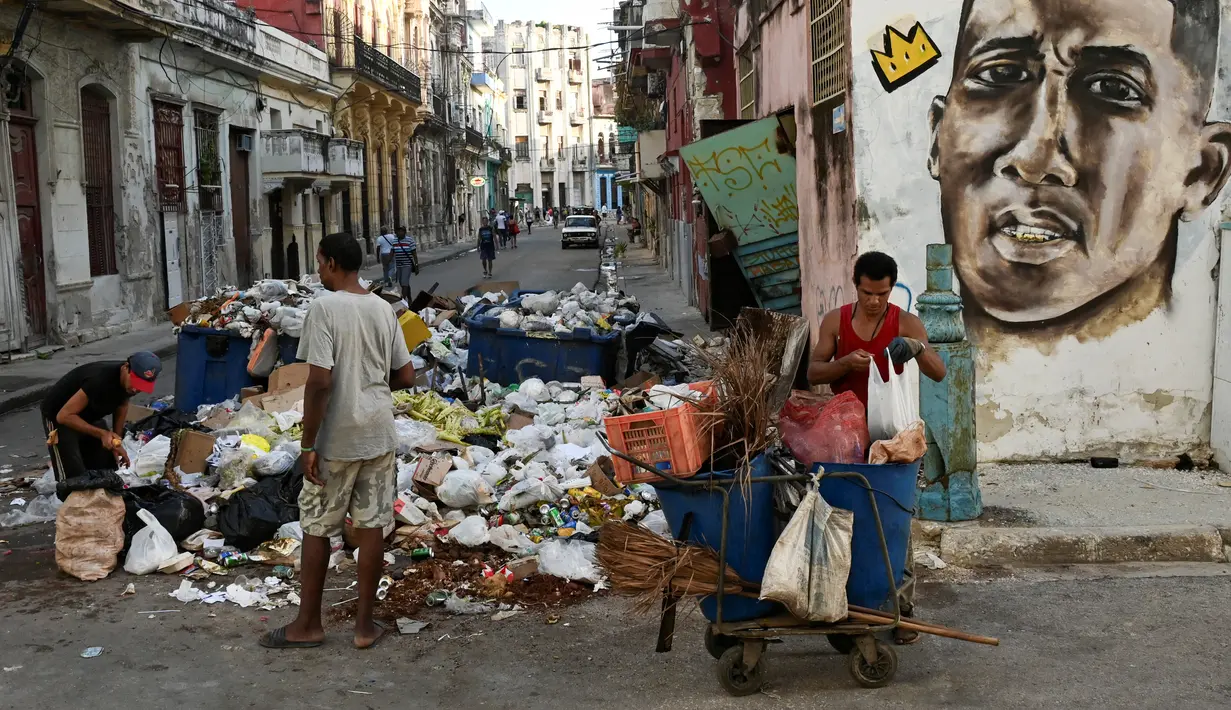 Warga Kuba mengumpulkan bahan mentah dari sejumlah besar sampah di sebuah jalan di Havana pada 23 Agustus 2024. (YAMIL LAGE / AFP)