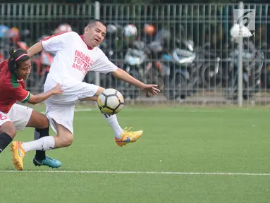 Pemain Timnas Wanita Indonesia (kiri) berebut bola dengan pemain tim Indonesian Football Ambassador di Lapangan C Kompleks GBK, Jakarta, Kamis (5/4). Uji tanding ini persiapan jelang Piala AFF Wanita 2018. (Liputan6.com/Helmi Fithriansyah)