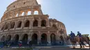 Polisi (kanan) dan petugas Carabinieri berpatroli di luar Colosseum di Roma, Italia, Senin (1/6/2020). Colosseum, yang merupakan ikon kota Roma dibuka kembali untuk umum pada Senin (1/6), setelah ditutup lebih dari dua bulan, dengan beberapa pembatasan akses bagi pengunjung. (AP/Domenico Stinellis)