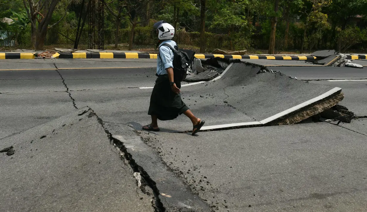 Seorang pria berjalan di sepanjang jalan yang rusak di Naypyidaw pada 28 Maret 2025. (Sai Aung MAIN/AFP)