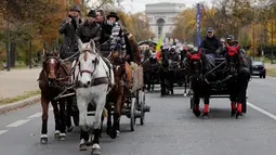 Sejumlah orang mengendarai kereta kuda saat meramaikan parade kuda ke-20 di Paris, Prancis (19/11). Mereka mengendarai kuda untuk menuju acara The 2017 Paris Horse Salon yang akan digelar pada 24-26 November 2017.(AFP Photo/Thomas Samson)