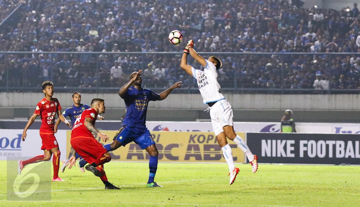 Penjaga Gawang Arema, Kurnia Meiga berusaha menepis bola dari kejaran pemain Persib Bandung pada laga perdana Liga 1 2017 di Stadion Gelora Bandung Lautan Api, Sabtu (15/4). Persib bermain imbang atas Arema FC dengan skor 0-0. (Liputan6.com/Yoppy Renato)