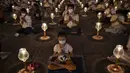 Umat Buddha mengenakan masker saat berdoa bersama setelah pemerintah Thailand mengumumkan 14 orang terkonfirmasi infeksi virus corona di kuil Buddha Wat Dhammakaya, Bangkok (31/1/2020). (AFP Photo/Lillian Suwanrumpha)