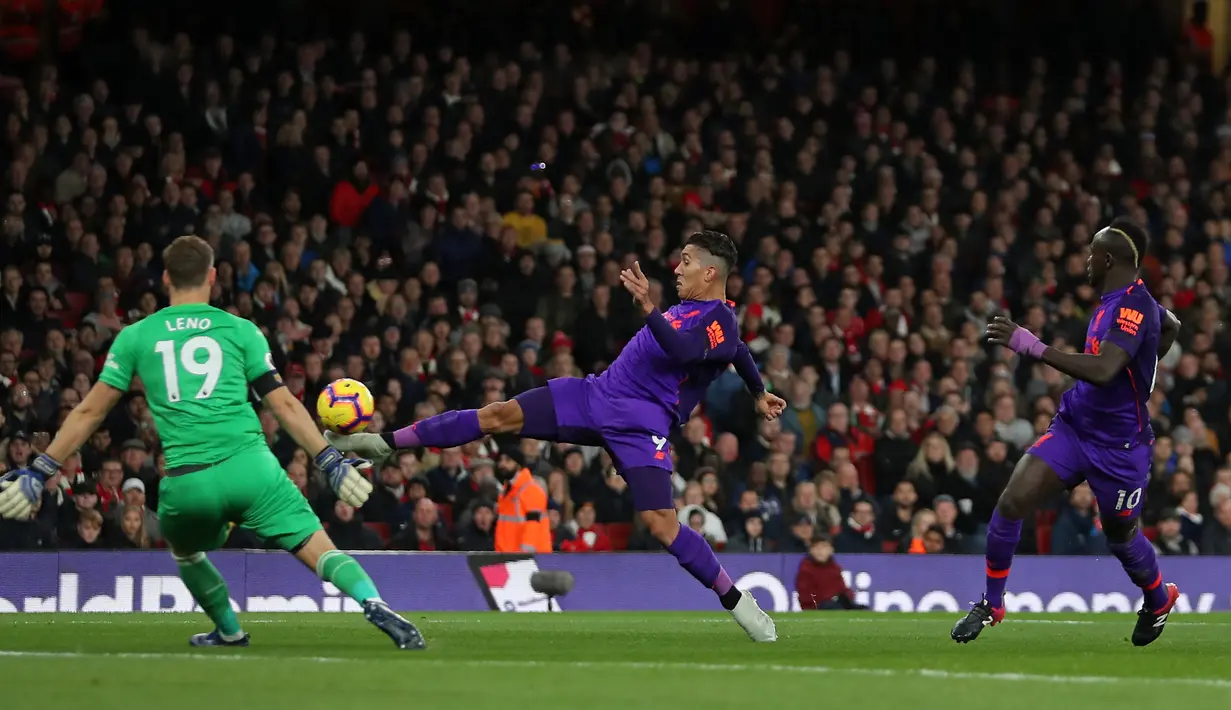 Striker Liverpool, Roberto Firmino, berusaha membobol gawang Arsenal yang dijaga Bernd Leno pada laga Premier League di Stadion Emirates, London, Minggu (3/11). Kedua klub bermain imbang 1-1. (AFP/Daniel Leal-Olivas)
